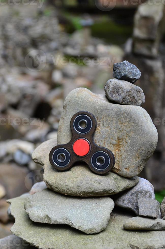 A wooden spinner lies on strange stone structures in the forest photo