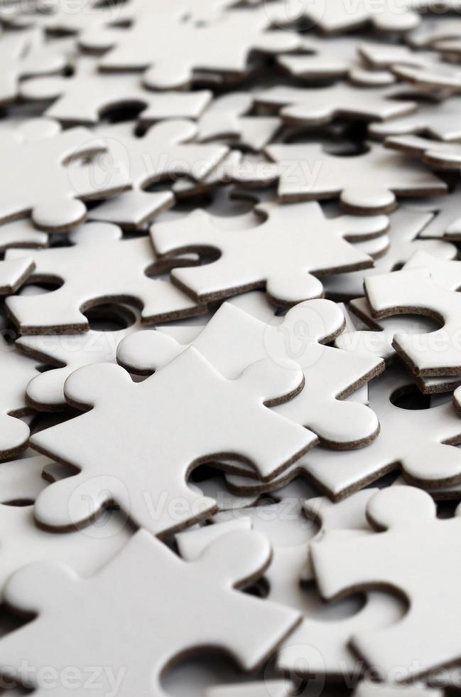 Close-up of a pile of uncompleted elements of a white puzzle. A huge number of rectangular pieces from one large white mosaic photo