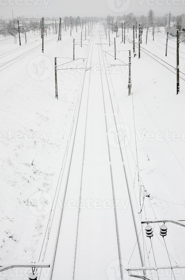 paisaje ferroviario de invierno, vías férreas en el país industrial cubierto de nieve foto