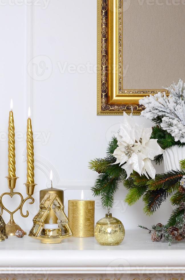 New Year and Christmas composition. Thick candles, candlestick, pot of flowers and framed canvas that hangs on the wall photo