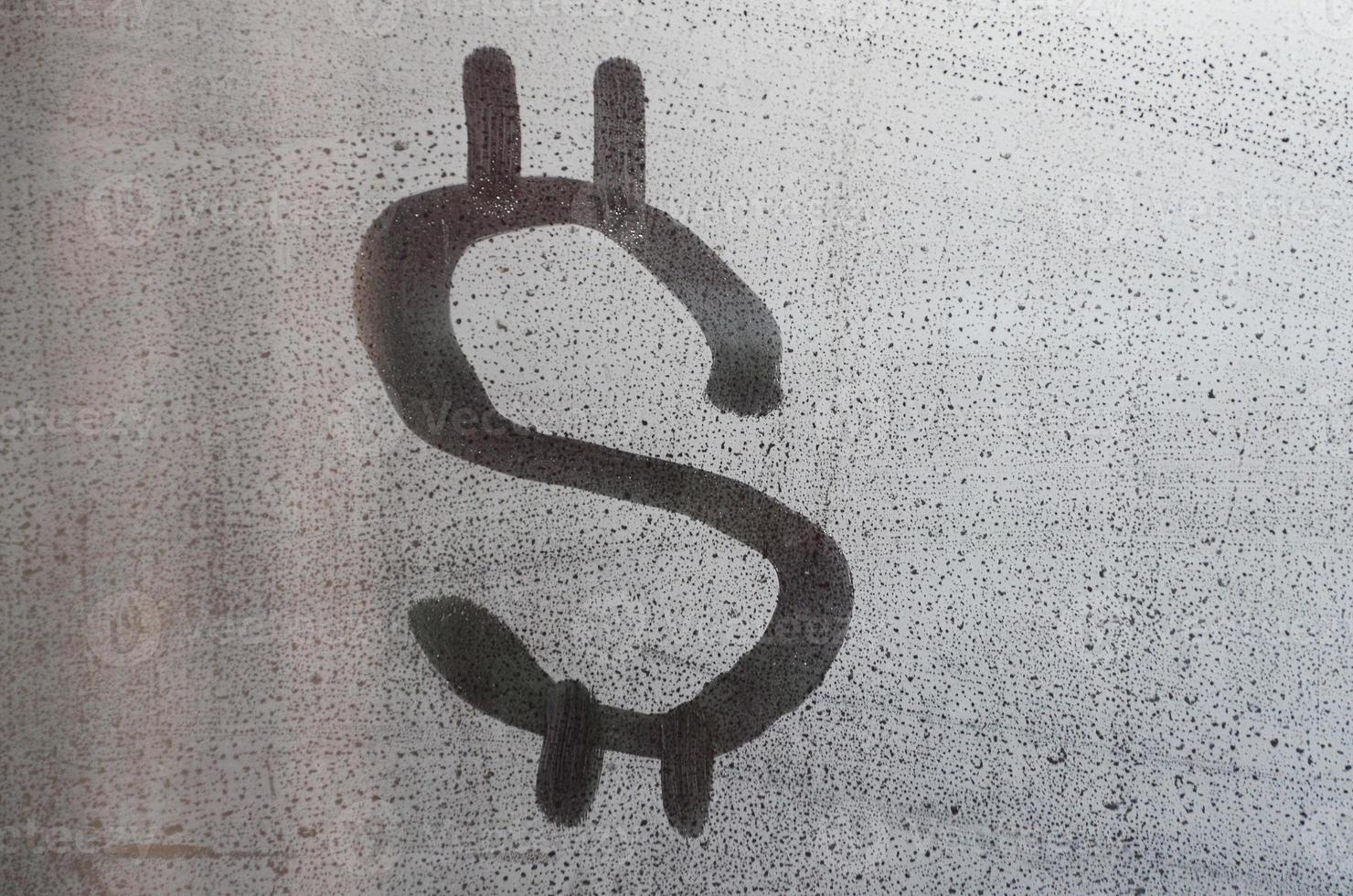 The dollar symbol on the misted sweaty glass. Abstract background image. US money concept photo