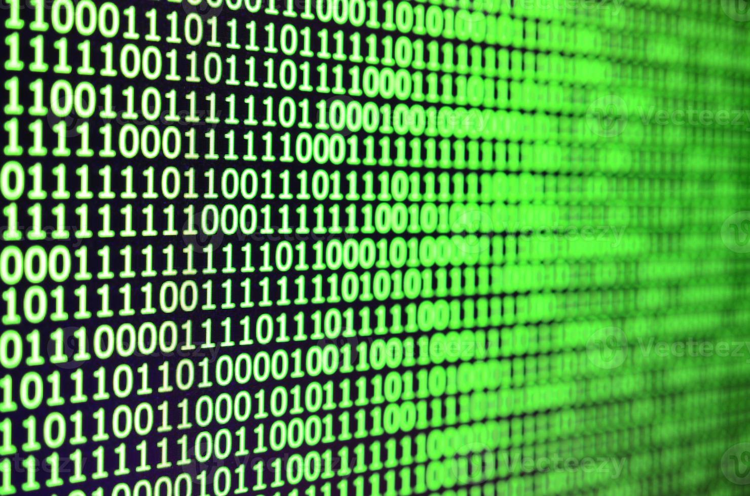 Macro shot of binary code on the monitor of an office computer. The concept of the programmer's work. The flow of digital information strings photo