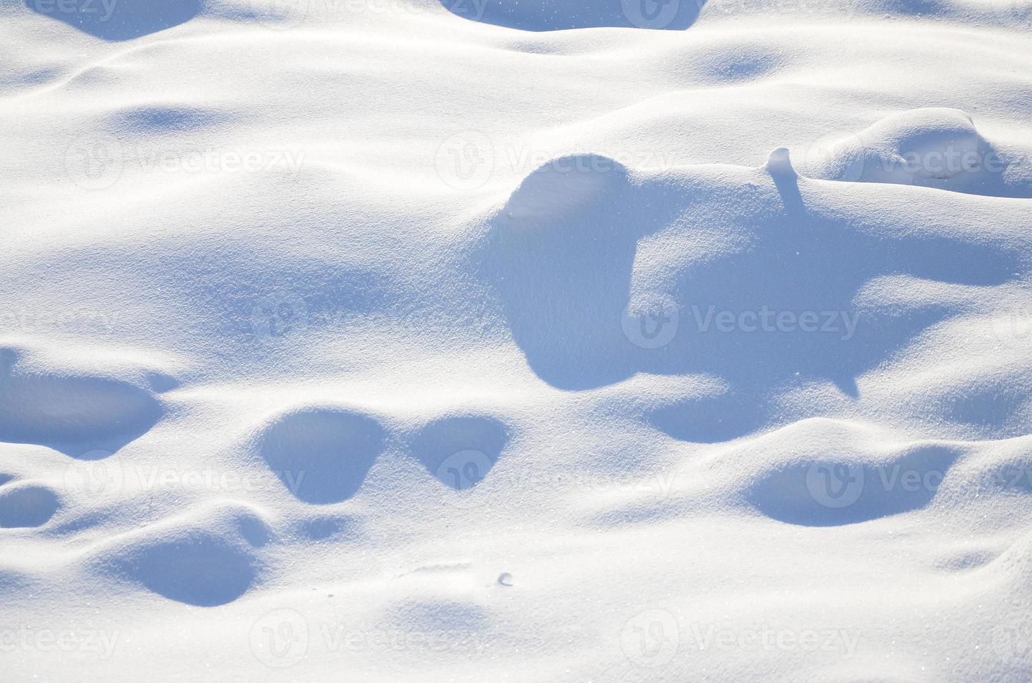 Fragment of the road, covered with a thick layer of snow. The texture of the glistening snow cover photo