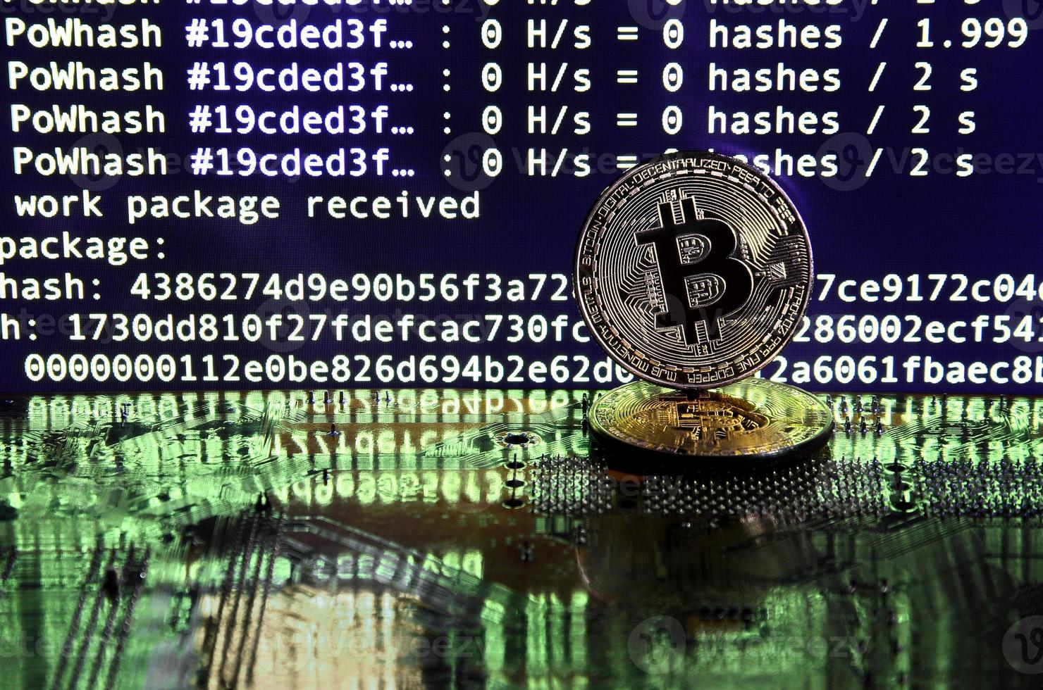 The digital process of cryptocurrency mining by using the GPUs. Bitcoins and video card on a working display and mining screen photo