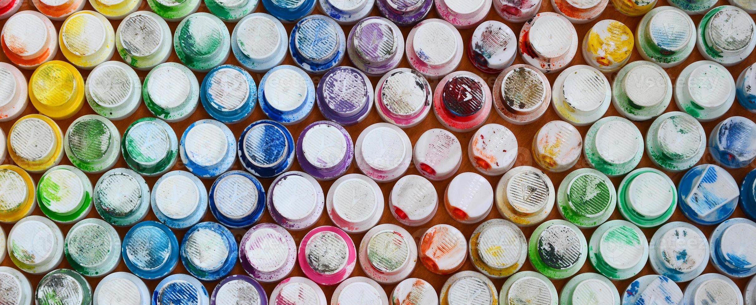 A pattern from a many nozzles from a paint sprayer for drawing graffiti, smeared into different colors. The plastic caps are arranged in many rows forming the color of the rainbow photo