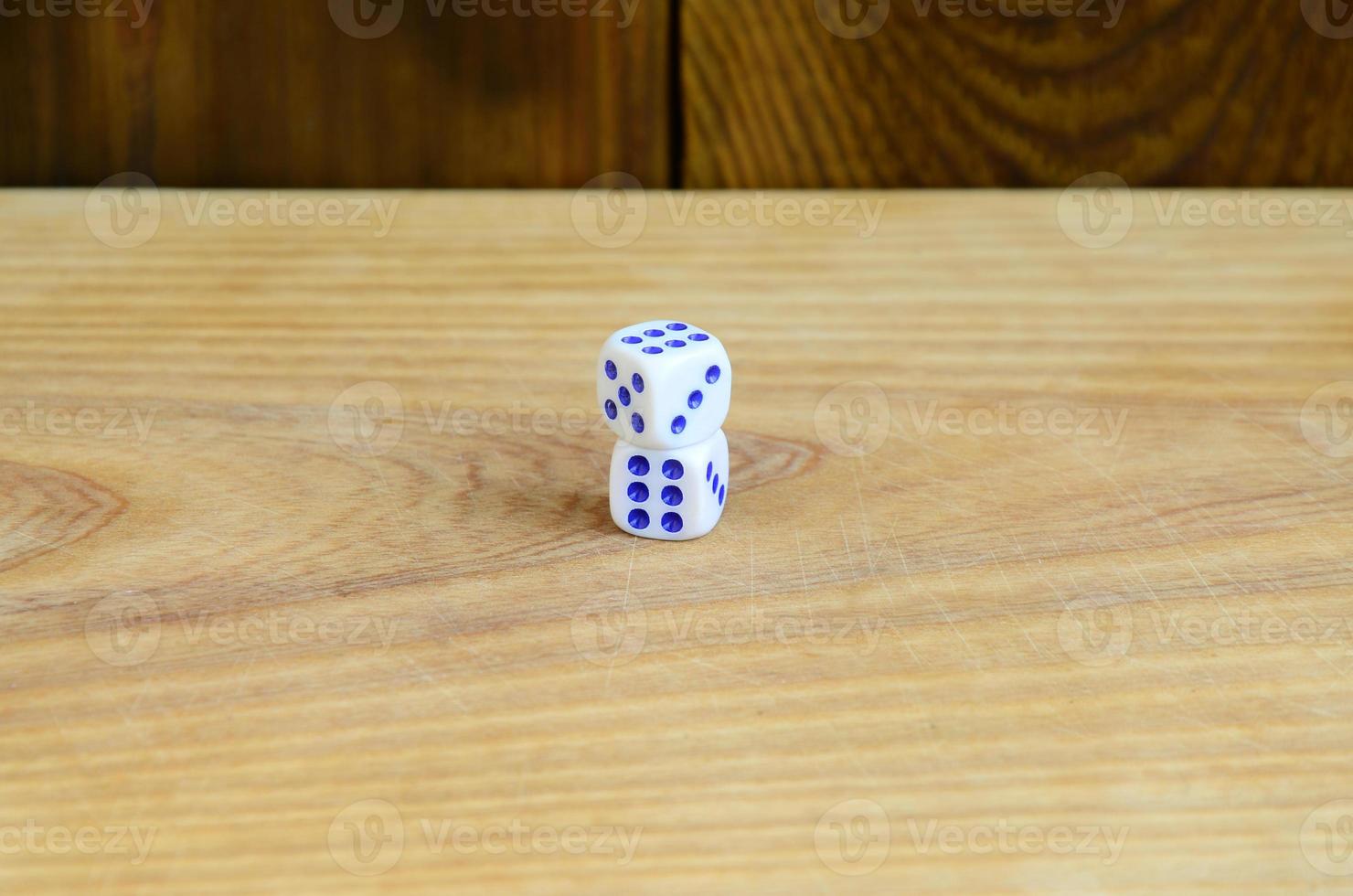 A few dice lies on the surface of natural wood. Items for generating numbers from one to six in the form of points that are painted on the side of cubes. The concept of gambling photo