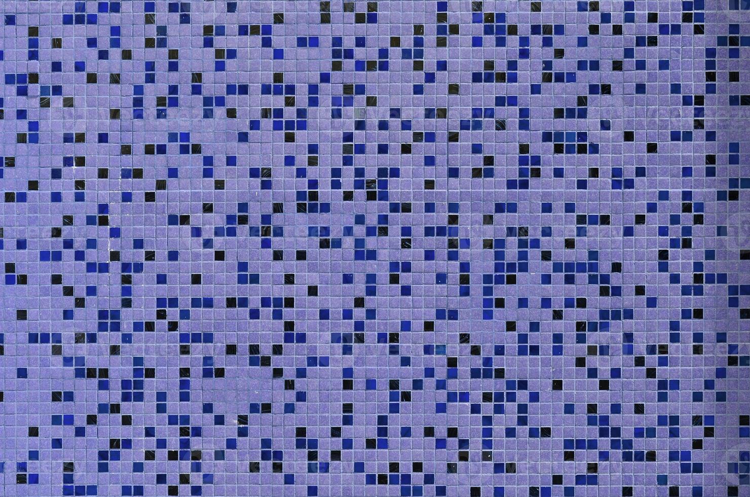 The texture of the wall, decorated with a mosaic of various small square tiles. Abstract pattern of ceramic tiles on the wall photo