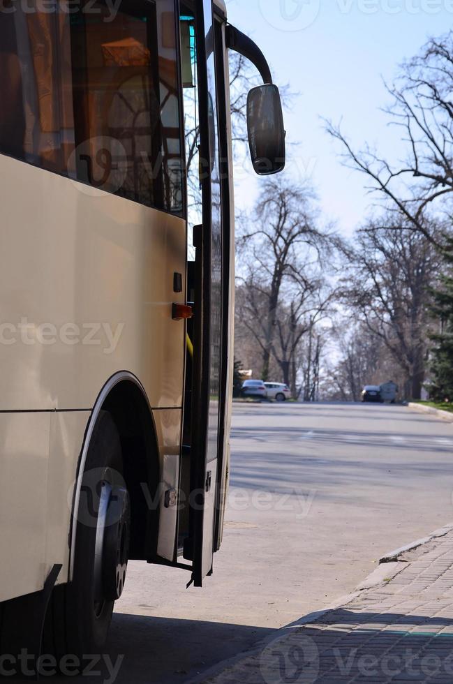 Photo of the hull of a large and long yellow bus. Close-up front view of a passenger vehicle for transportation and tourism