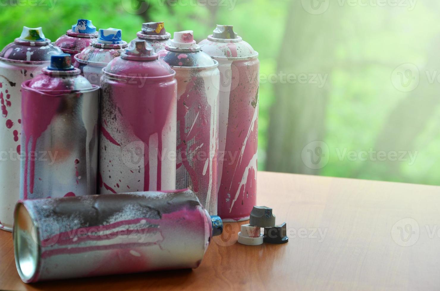 A lot of used spray cans of paint close-up. Dirty and smeared cans for drawing graffiti. The concept of a sweeping and careless drawing of paint. Creative art image photo