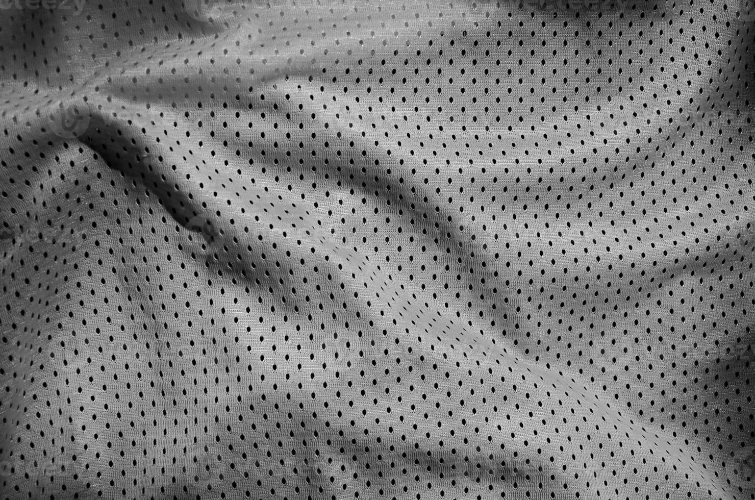 Grey sport clothing fabric texture background. Top view of grey cloth textile surface. Dark basketball shirt. photo
