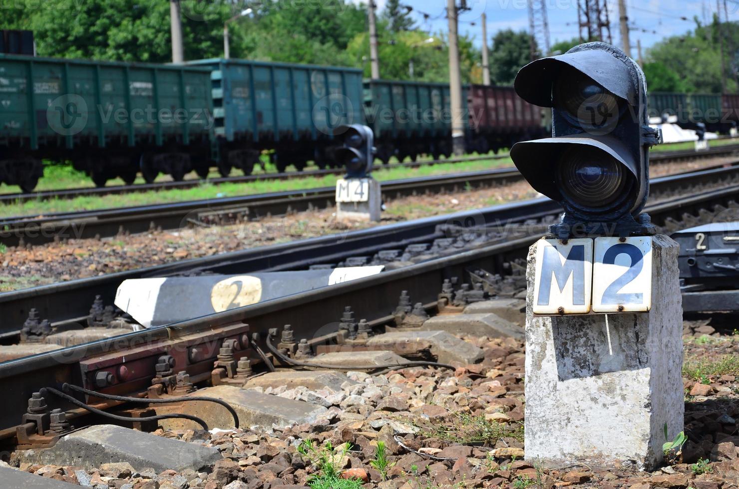 Railway traffic light semaphore against the background of a day railway landscape. Signal device on the railway track photo