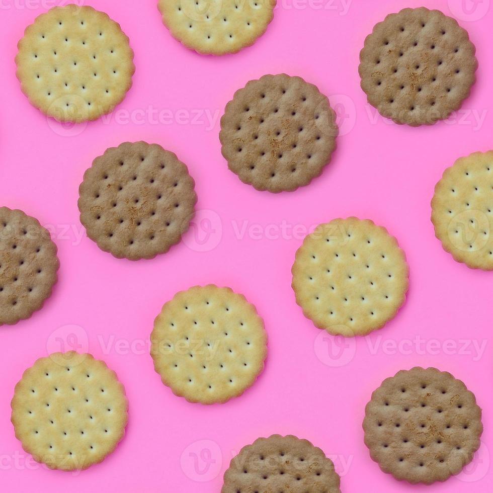 Pattern of a brown biscuits on a pink background. Trendy minimal concept of food and dessert. Abstract flat lay, top view photo