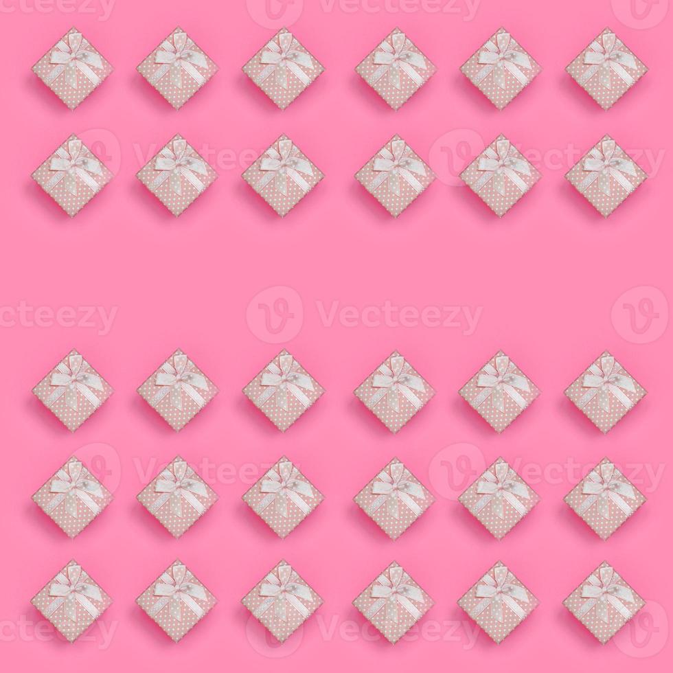 A lot of pink gift boxes lies on texture background of fashion pastel pink color paper in minimal concept. Abstract trendy pattern photo