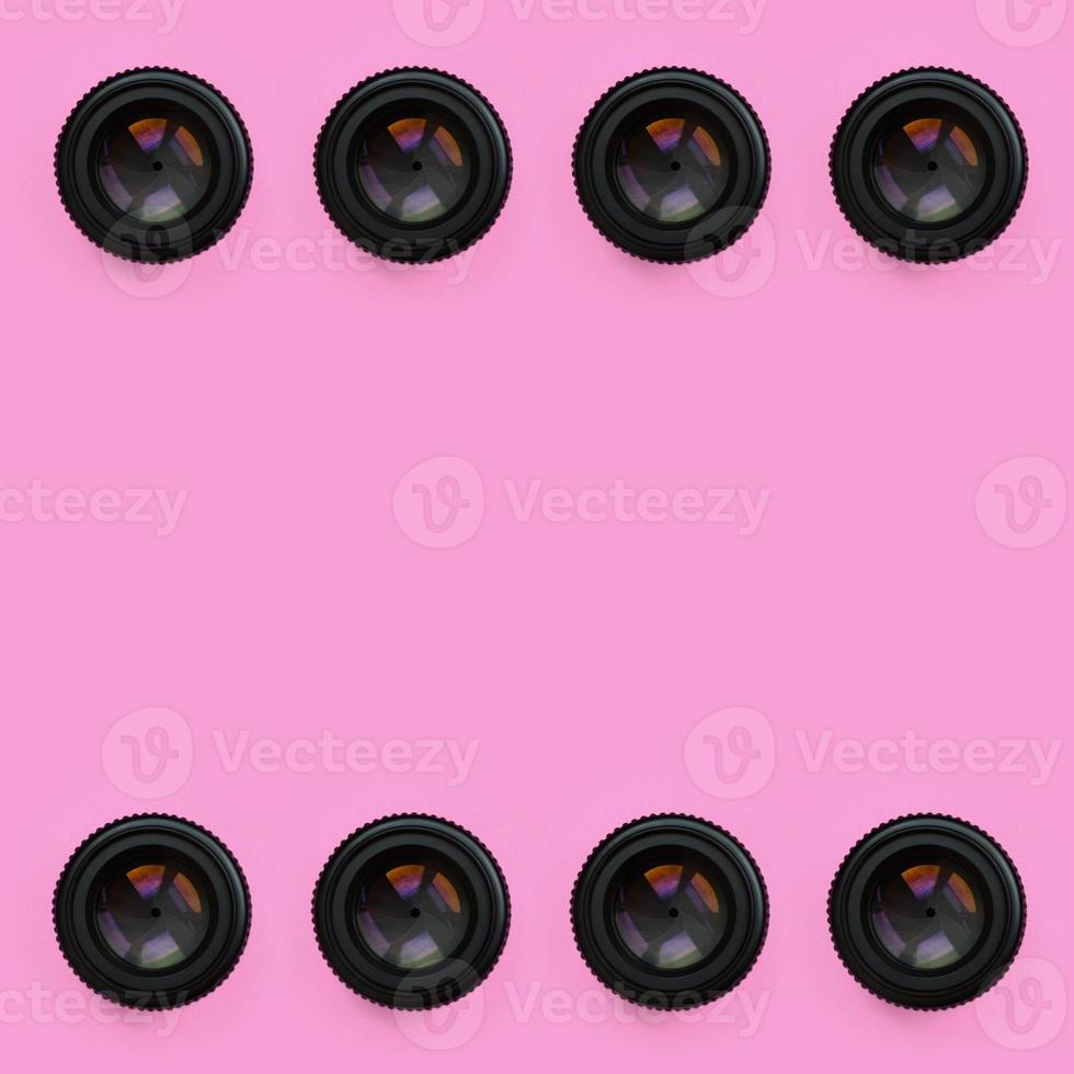 A few camera lenses with a closed aperture lie on texture background of fashion pastel pink color paper in minimal concept. Abstract trendy pattern photo