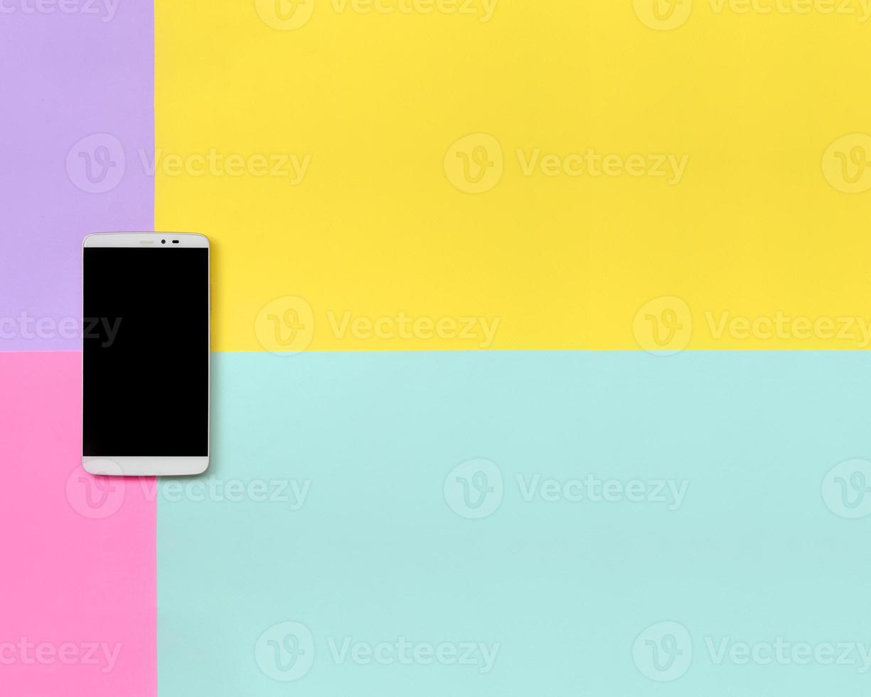 Modern smartphone with black screen on texture background of fashion pastel blue, yellow, violet and pink colors paper in minimal concept photo
