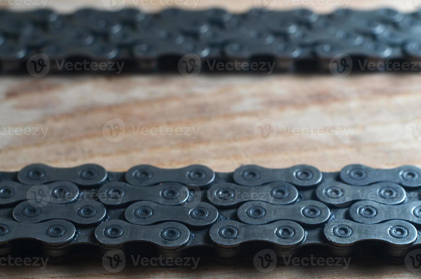Dirty and oily chain from a mountain bike lying on a wooden table in a bicycle shop photo