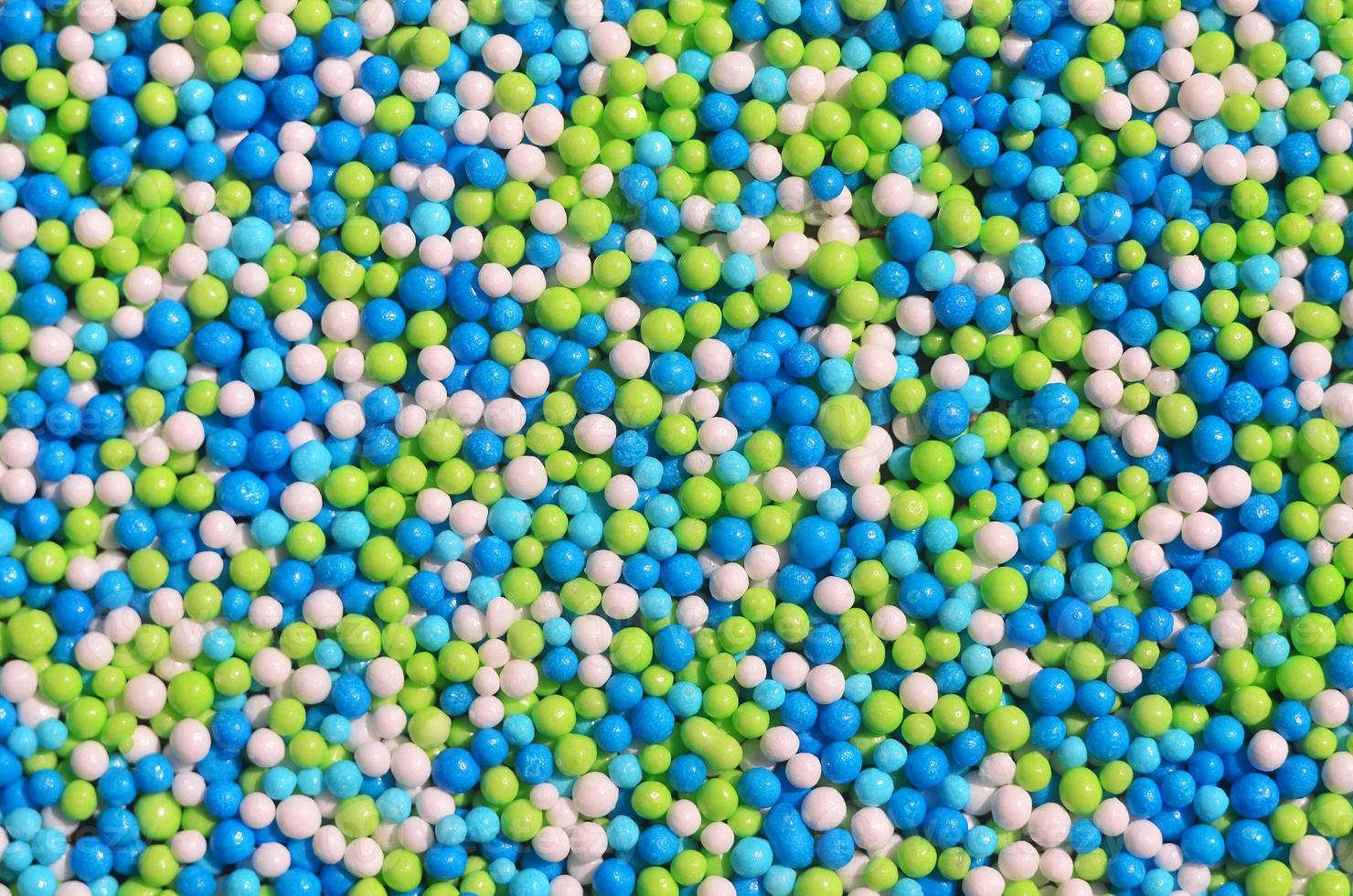 Background picture of a variety of colored glazed powder in the form of small balls photo