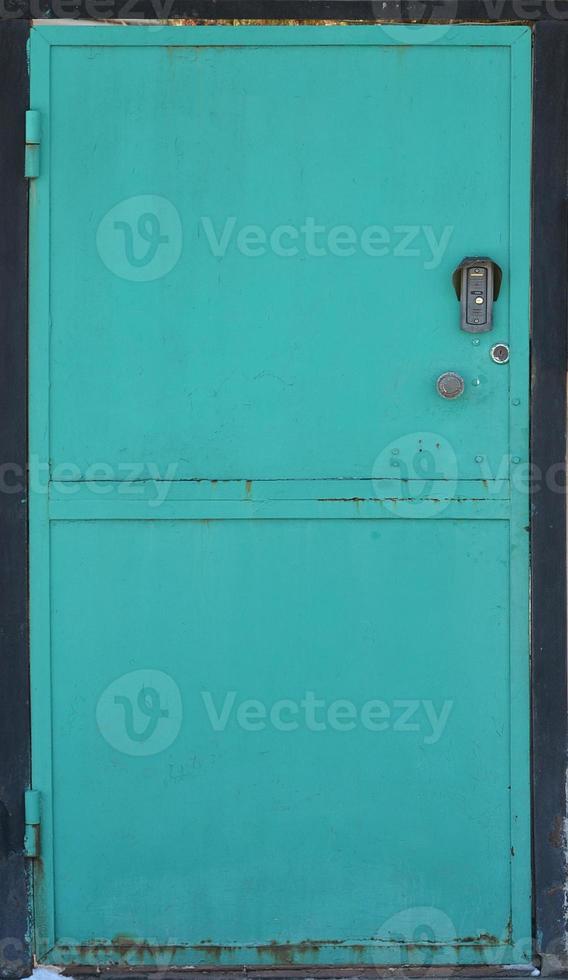 la textura de una puerta de metal pintada de una pared de ladrillo foto