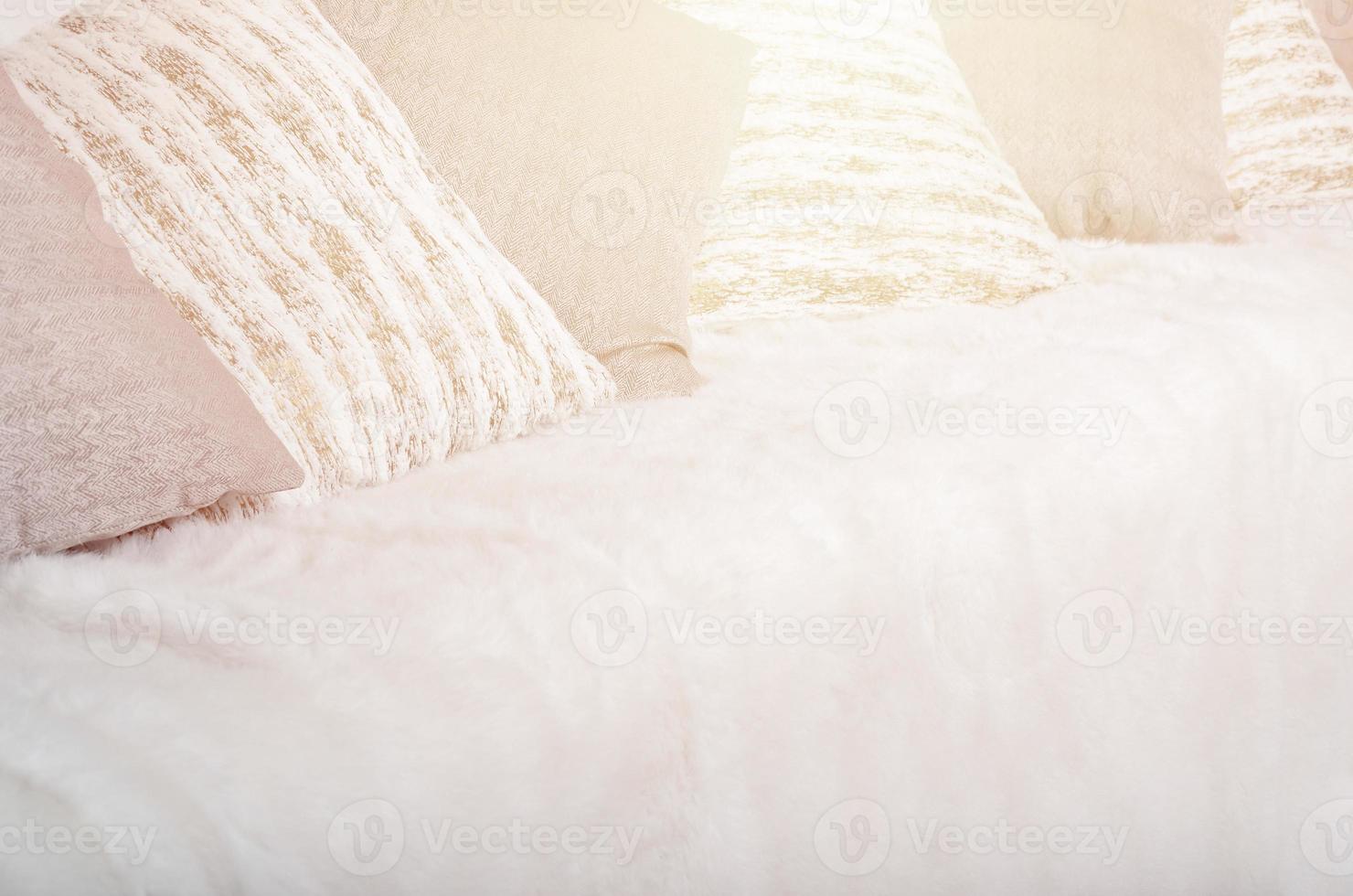 Many pillows lie on the couch, which is covered with a large plush veil photo