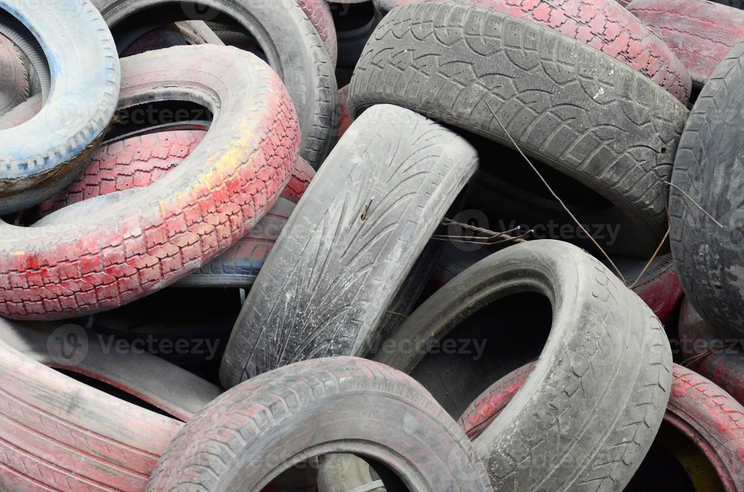 A picture of many old used tires left on a waste dump photo