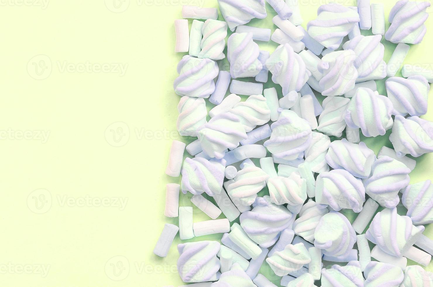 Colorful marshmallow laid out on lime paper background. pastel creative texture photo