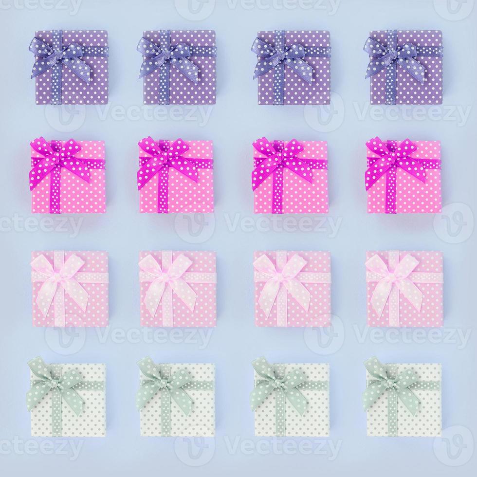 Piles of a small colored gift boxes with ribbons lies on a violet background photo