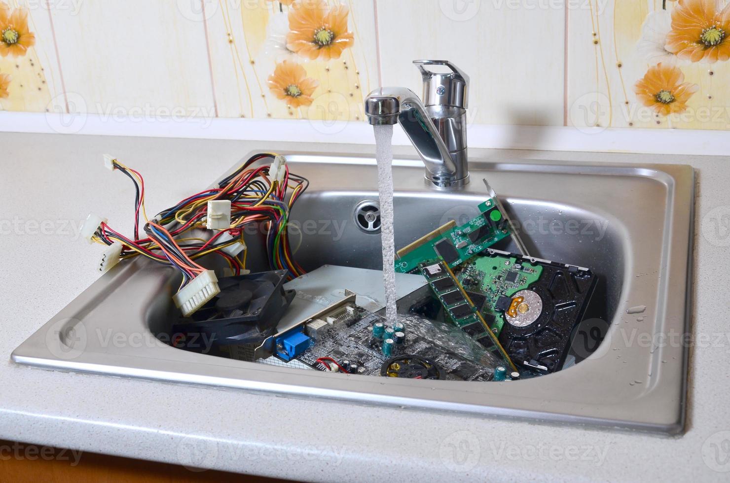 Hardware in kitchen sink under the water flow computer cleaning metaphoric concept photo