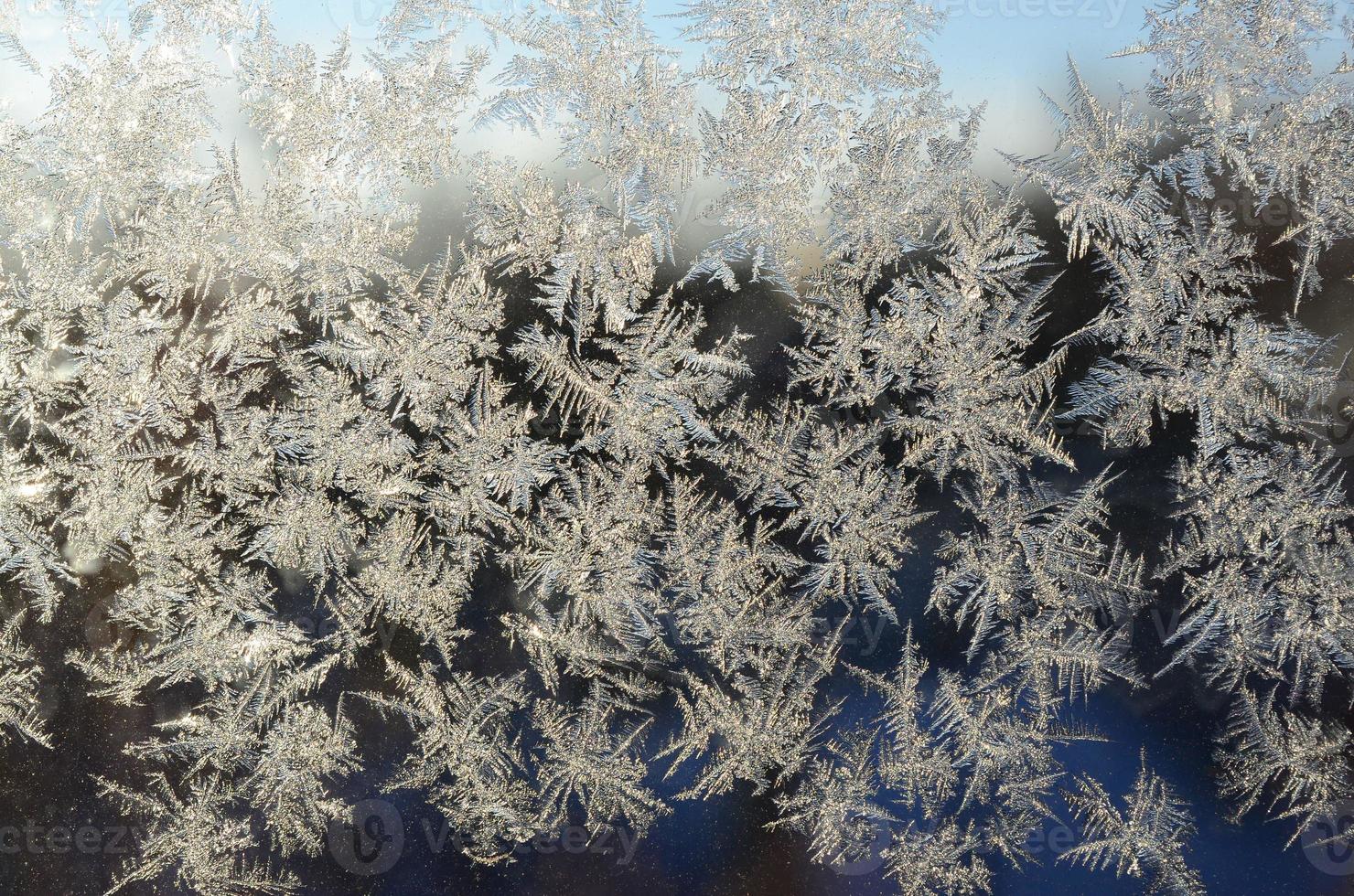 Snowflakes frost rime macro on window glass pane photo