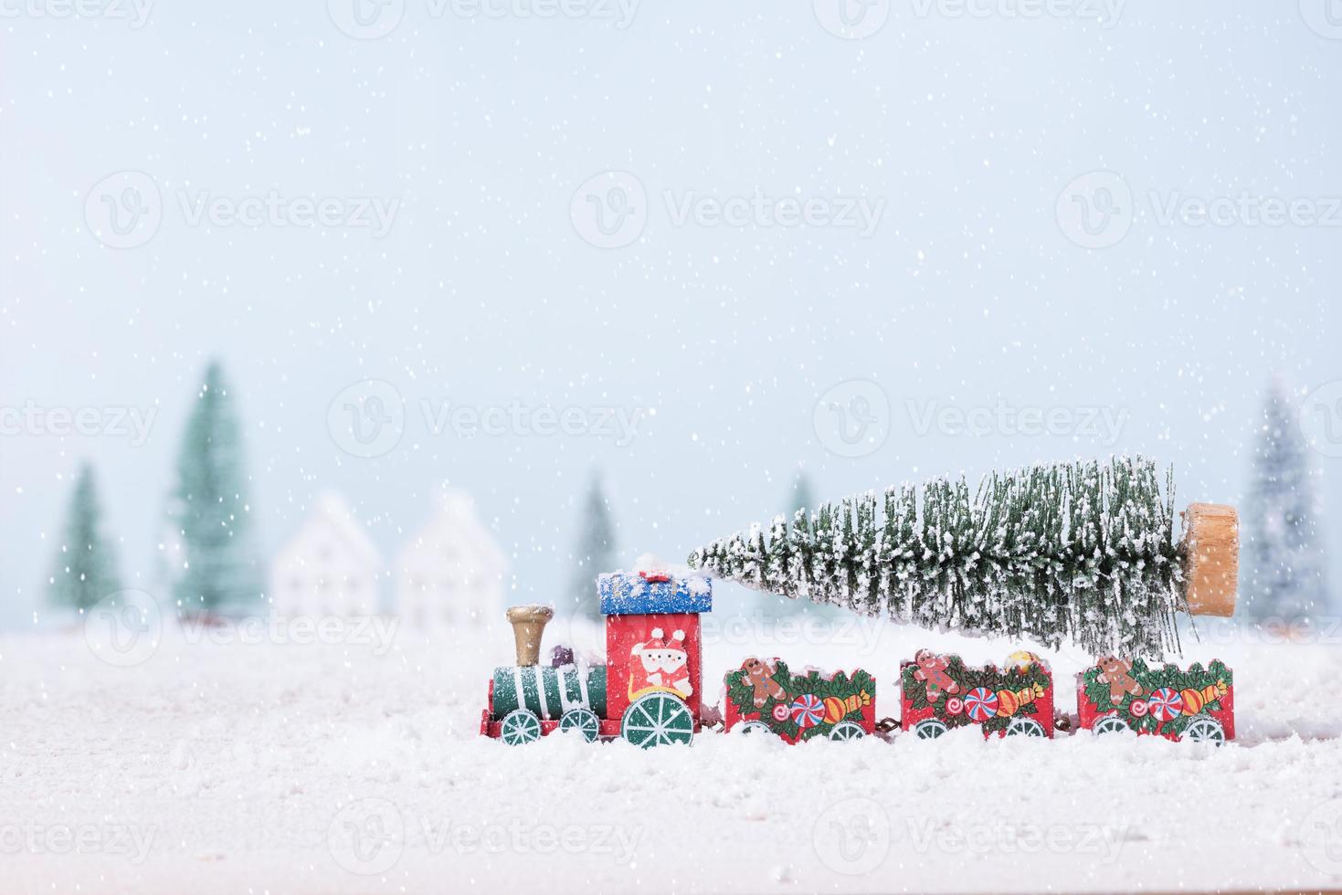 Christmas tree on toy train was running through the snow in the field of natural Landscape background photo