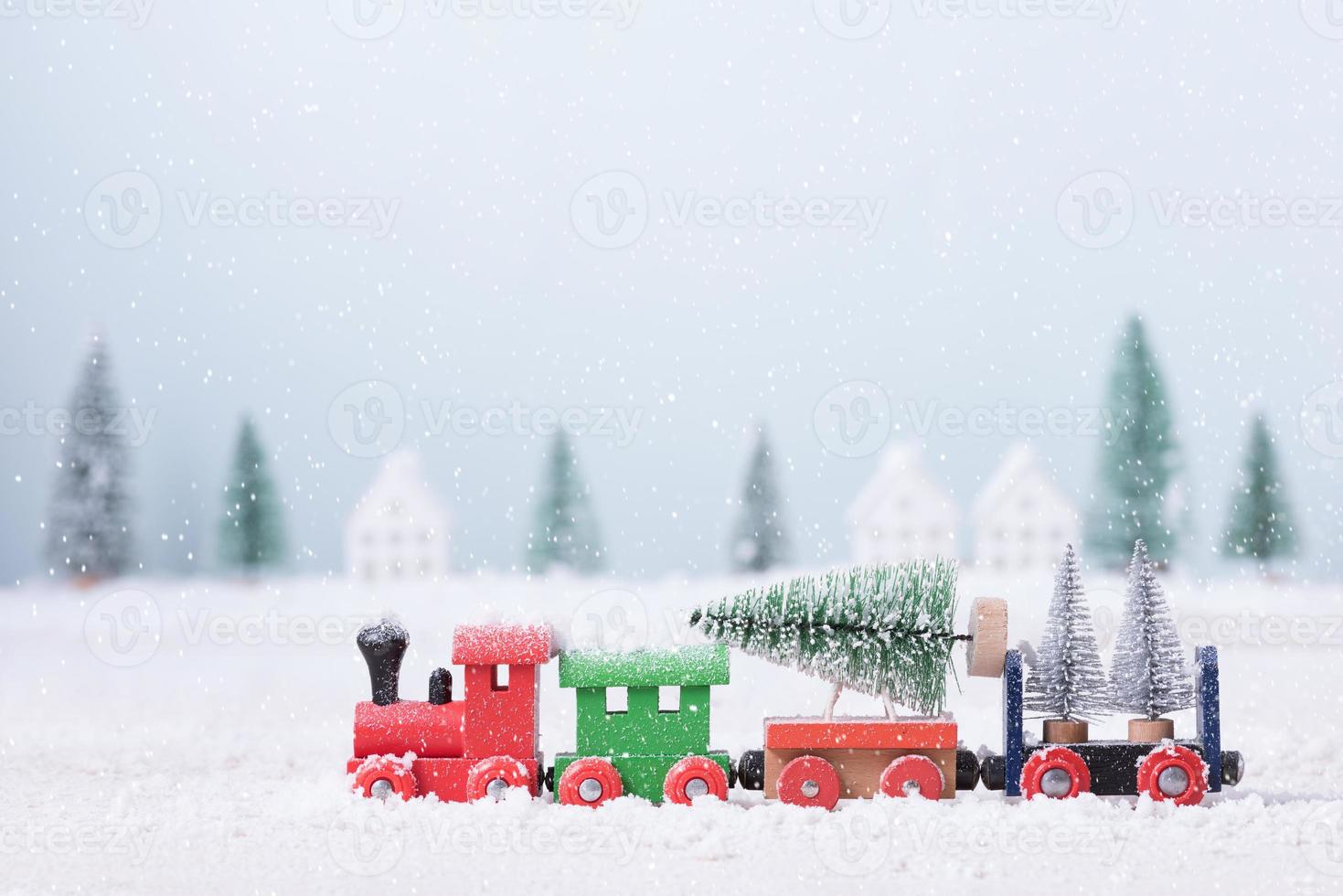 árbol de navidad en tren de juguete corría a través de la nieve en el campo de fondo de paisaje natural foto