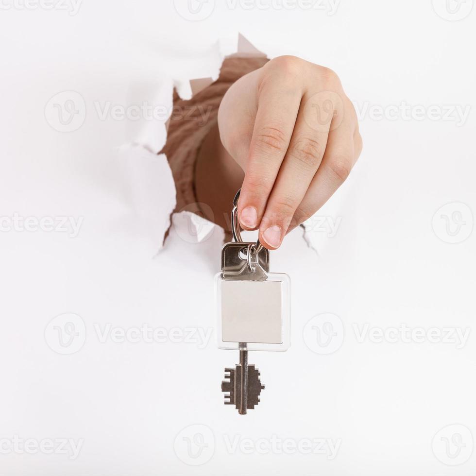 hand holds the keychain through a hole photo