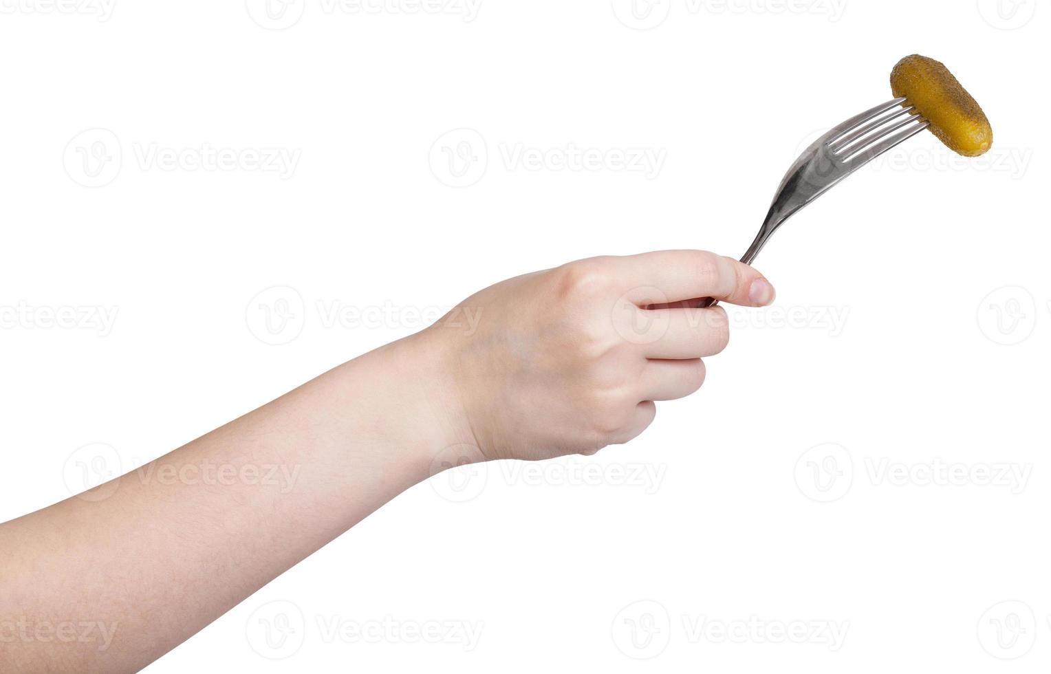 hand holding fork with impaled salted cucumber photo