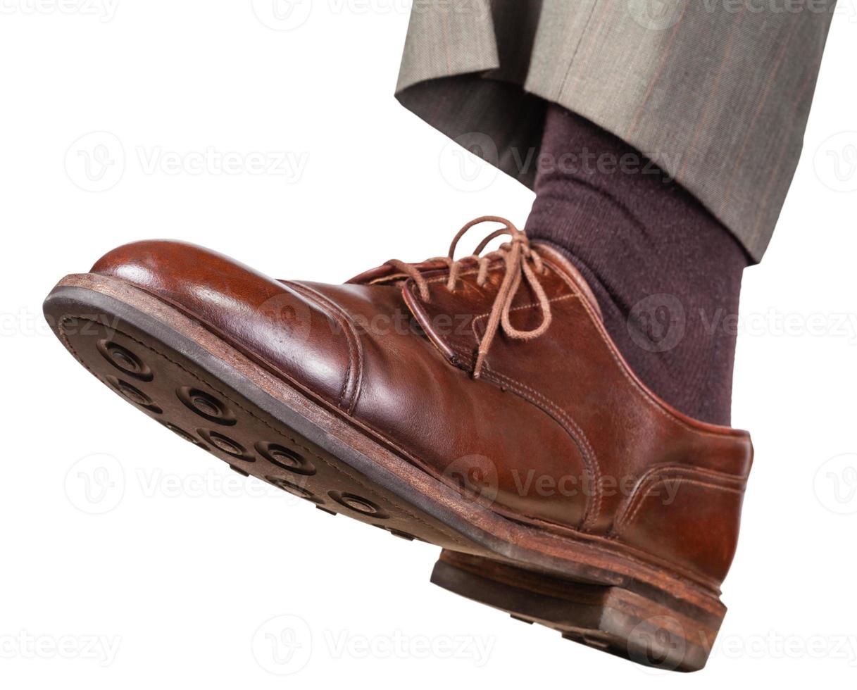 male left foot in brown shoe takes a step photo