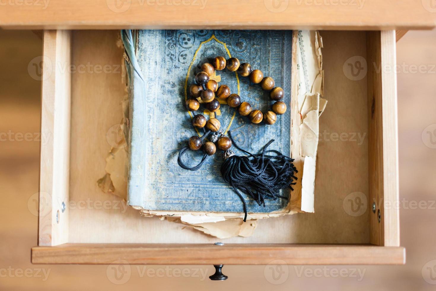 rosario en raído libro religioso en cajón abierto foto