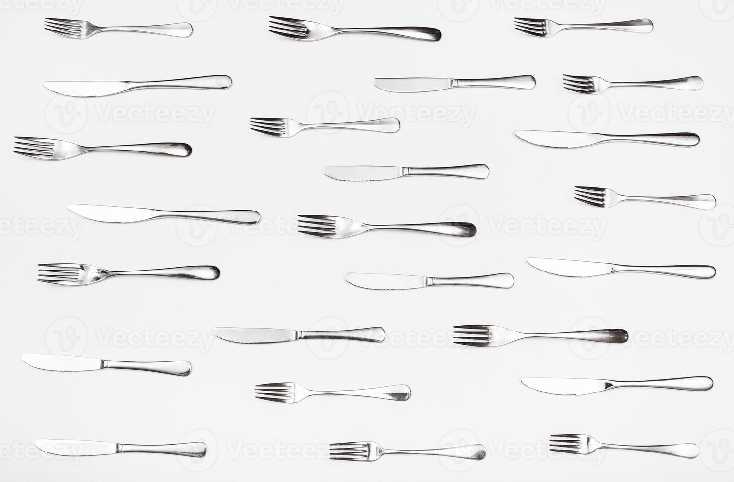 top view of many table knives and forks on white photo