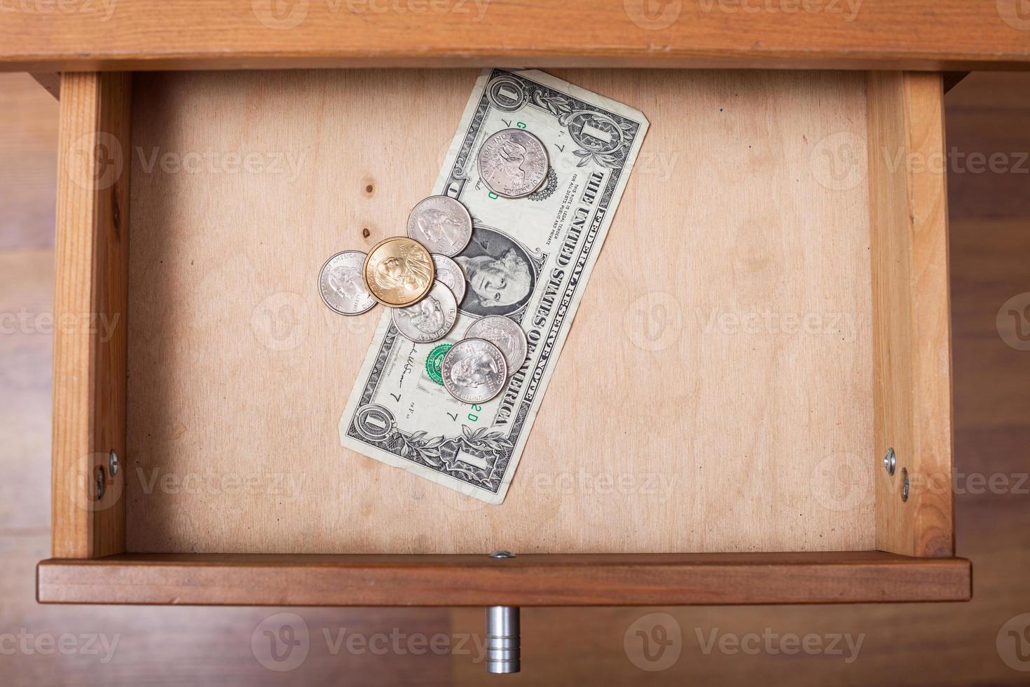 one US Dollar and coins in open drawer photo
