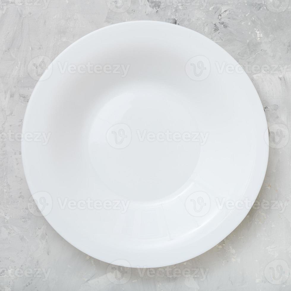 above view of white deep plate on concrete board photo