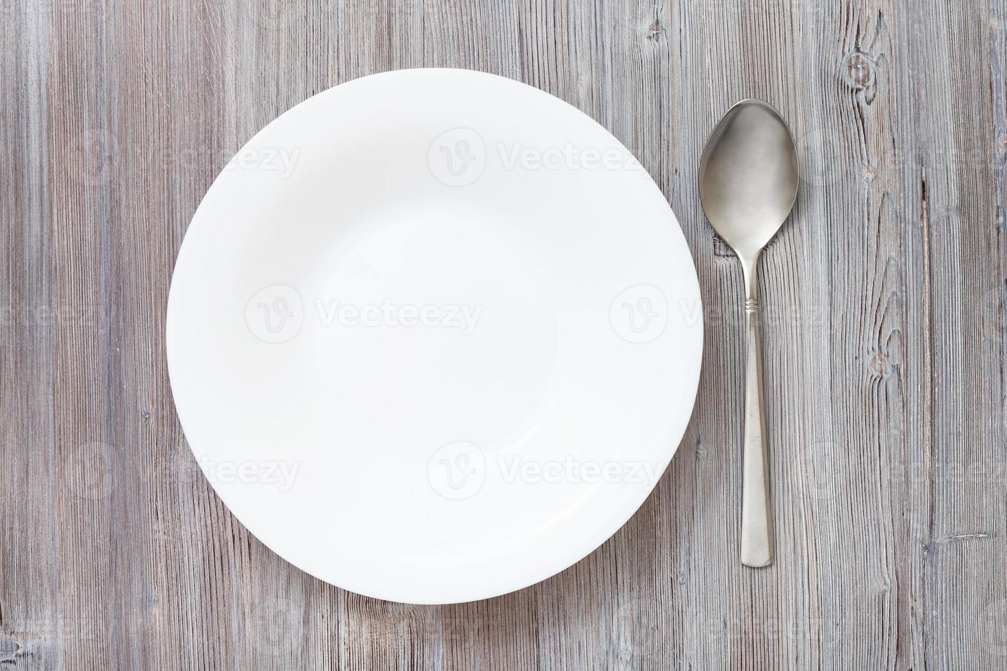 top view deep plate and spoon on gray brown table photo