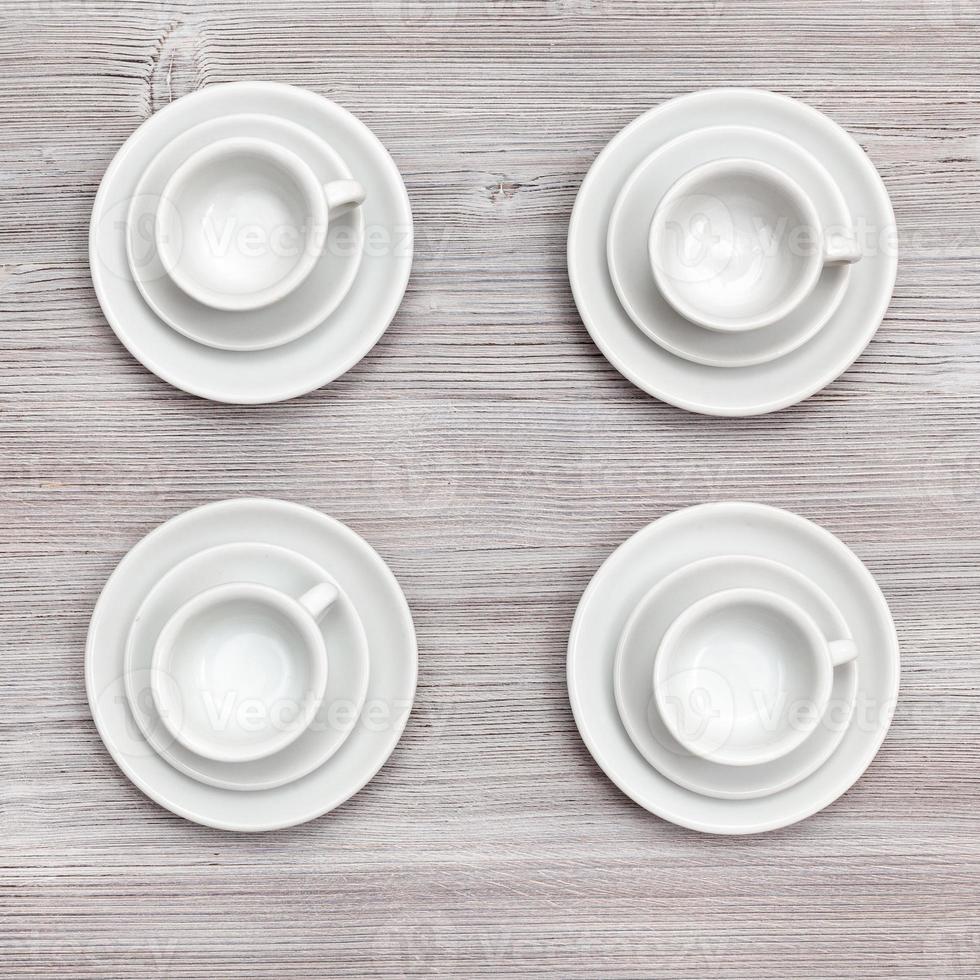 top view of four cups and saucers on gray board photo