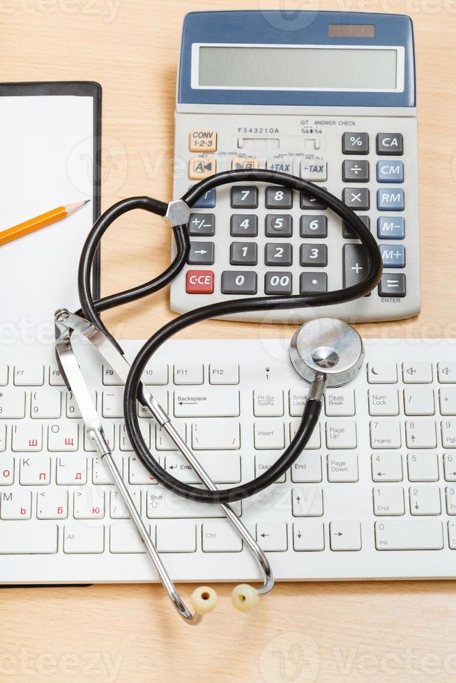 phonendoscope on keyboard, calculator, clipboard photo