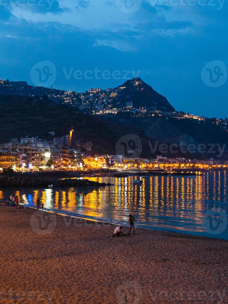 playa urbana en la ciudad de giardini naxos en la noche de verano foto