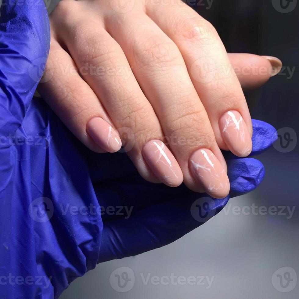 professional pink female manicure on nails close up photo