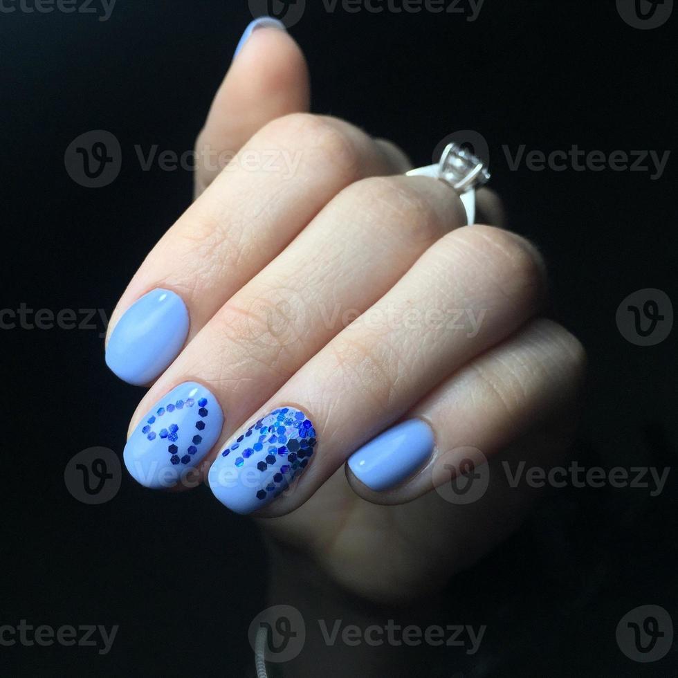 manicura azul en las uñas. manicura femenina en la mano foto
