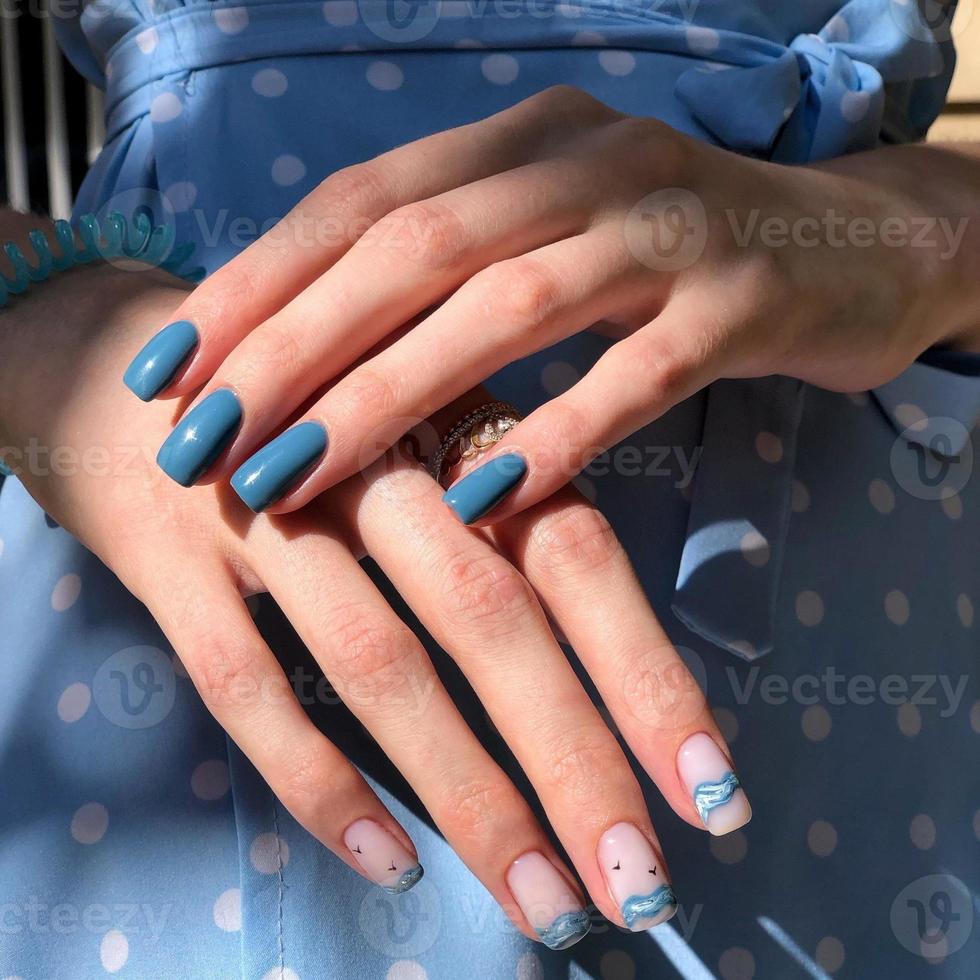 blue female manicure on nails close up photo