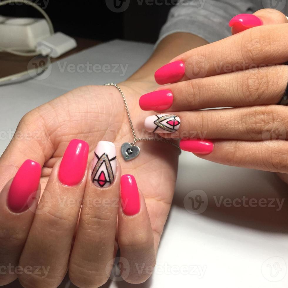 manos femeninas con elegante manicura roja sobre fondo gris foto