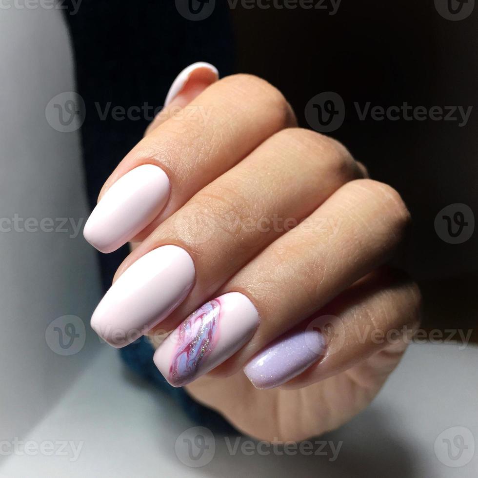 manos femeninas con elegante manicura rosa sobre fondo blanco foto