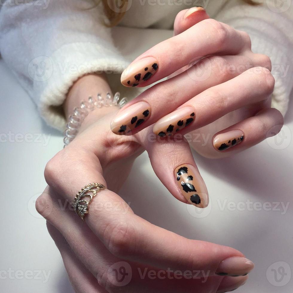 manicura francesa en mangos gruesos de mujer con diseño de leopardo. foto