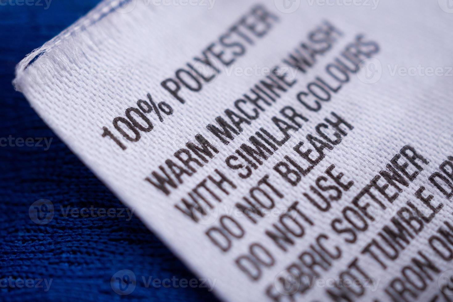 Polyester clothing label with laundry care instructions tag on blue shirt jersey photo