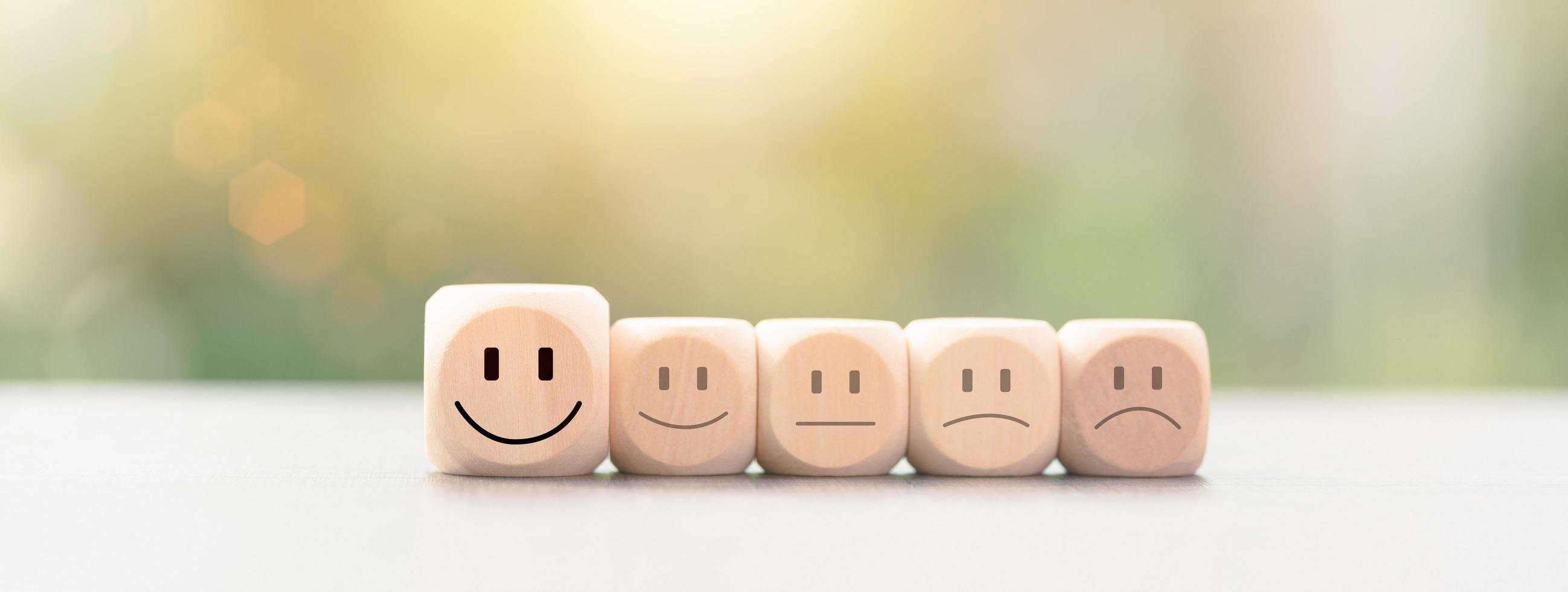 Customer experience survey concept for service and product and customer engagement, best satisfaction rating, positive feedback, wooden blocks lined up on the table, smiley icon, nature background photo