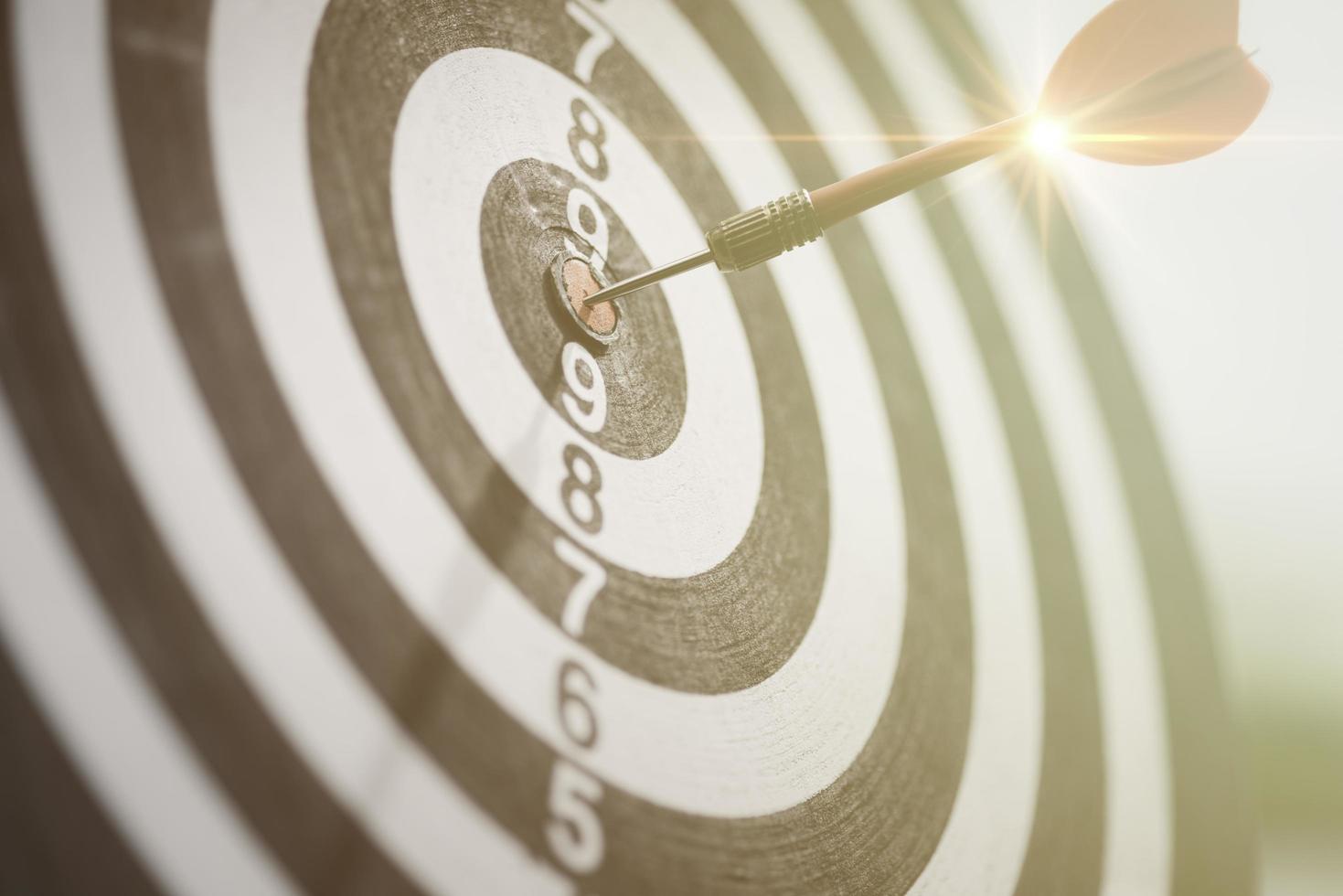dart arrow hitting in the target center of dartboard, setting business goals, formulating success strategies and goals, planning and managing the future for business growth. photo